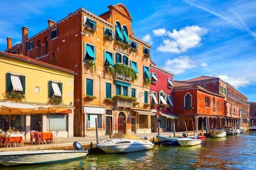 A canal with colorful buildings and boats docked along the water. 5