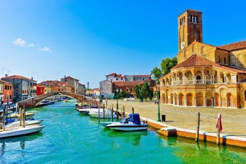 A canal with boats, a bridge, and historic buildings. 1