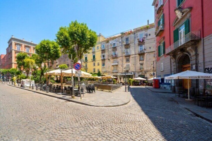 A cobblestone street lined with cafes and buildings. 3