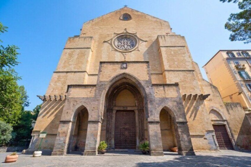 A historic church with a large arched entrance and a clock above it. 5