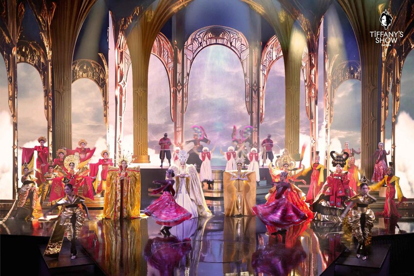 A stage with performers in elaborate costumes, a gothic arch design, and a reflective floor. 3