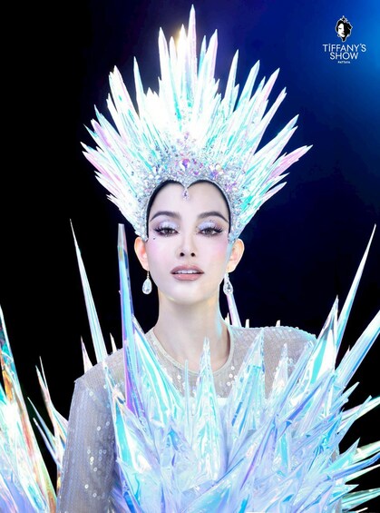 A person wearing a sparkling, crystal-like headdress and a sequined garment. 1