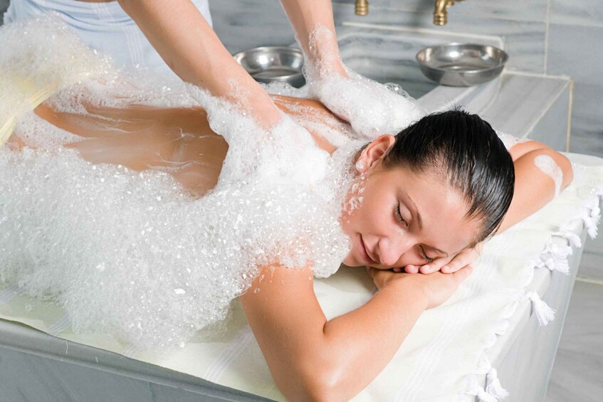 A person receiving a bubble bath treatment in a spa setting. 2