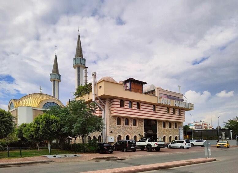 A mosque with a minaret and a modern building with a sign reading 'LARA HAMA'. 5