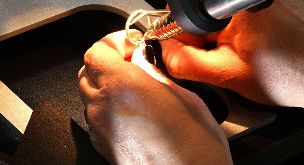 A person using a soldering iron on a circuit board. 4