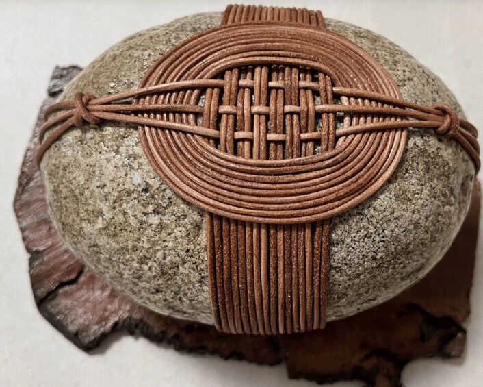 A woven leather bracelet on a rock. 1