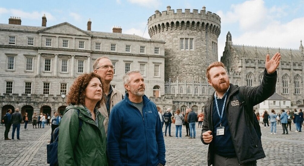 A group of people in front of a historic building with a large tower. 1