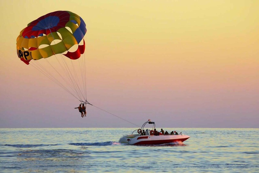 A parasailing activity with a colorful parachute and a speedboat in the water. 3