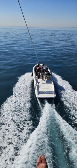 A boat moving through calm water, creating a wake behind it. 4