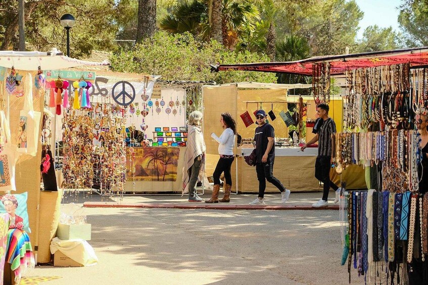 A street market with stalls selling jewelry and textiles. 2