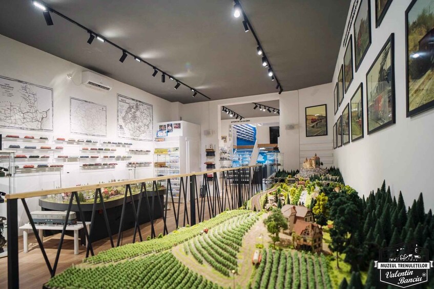 A museum interior with model train displays, maps, and a model landscape. 4