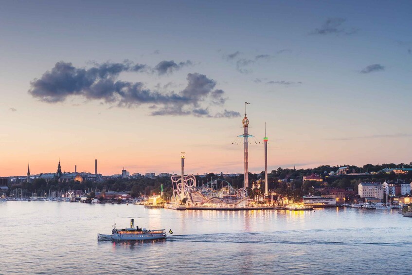 A waterfront cityscape at dusk with a prominent amusement park and a boat in the foreground. 4
