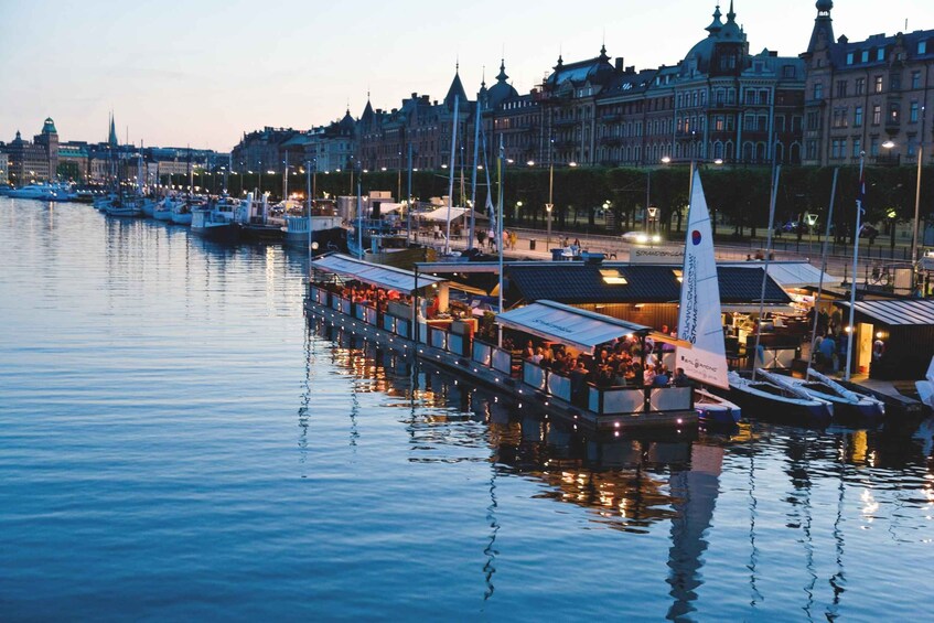 A waterfront with boats docked, a row of restaurants, and historic buildings in the background. 5