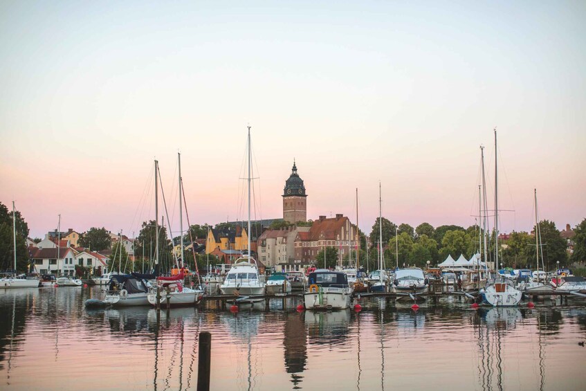 A marina with boats docked, a clock tower, and buildings in the background. 3