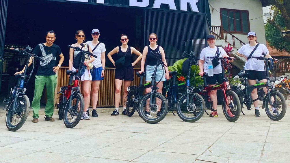 A group of people standing in front of a building with a sign that reads 'BAR'. 4