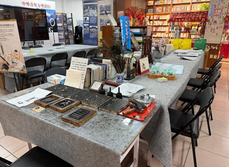 A bookstore with a display table featuring books, a keyboard, and various stationery items. 3