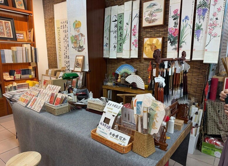 A bookstore with shelves of books, a display of calligraphy, and a fan. 4