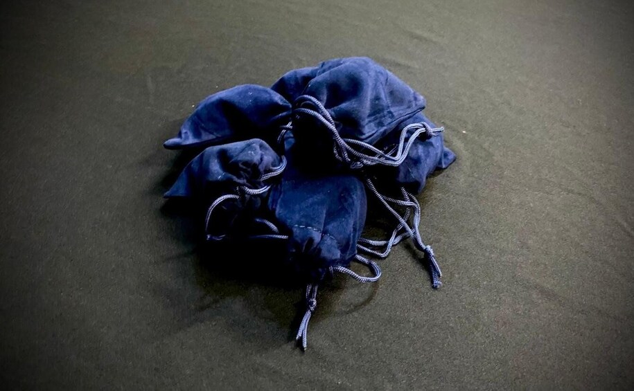 A blue drawstring bag on a textured surface. 2