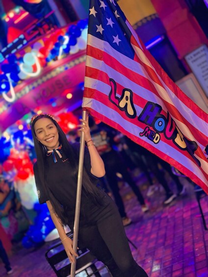A person holding an American flag with 'La Houa' written on it. 5
