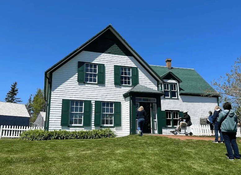 A white house with green shutters and a green roof. 3