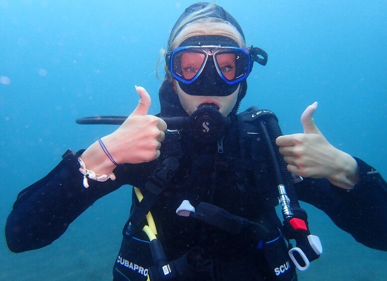 A scuba diver giving a thumbs up underwater. 5
