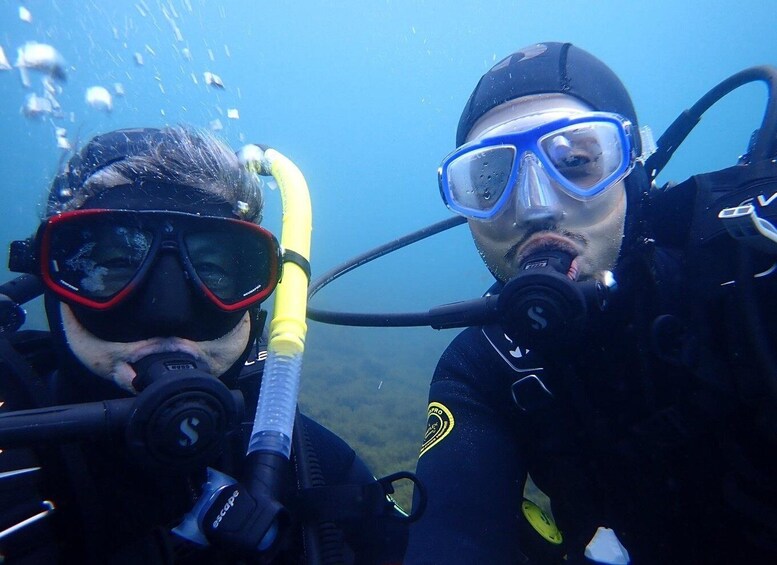 Two scuba divers underwater with scuba gear and a diver's mask. 4
