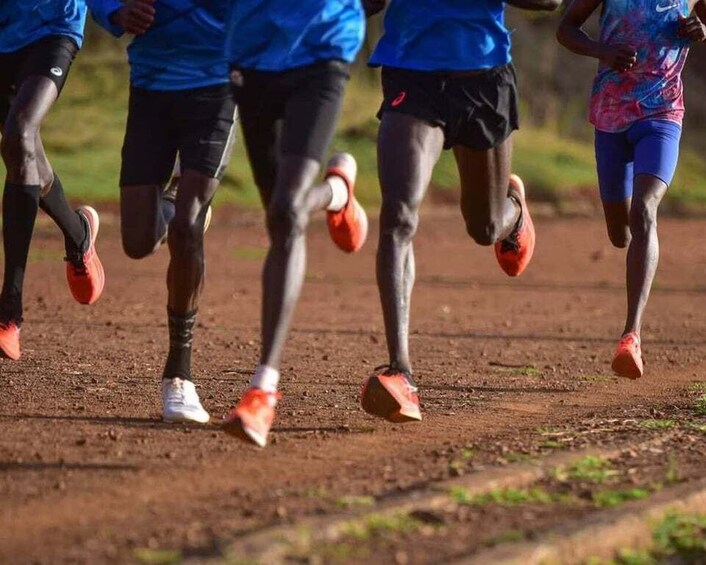 A group of runners on a dirt track. 3