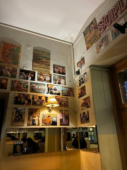 A wall adorned with numerous photographs and posters, a prominent 'SOPL' sign, and a 'BEER' sign. 3