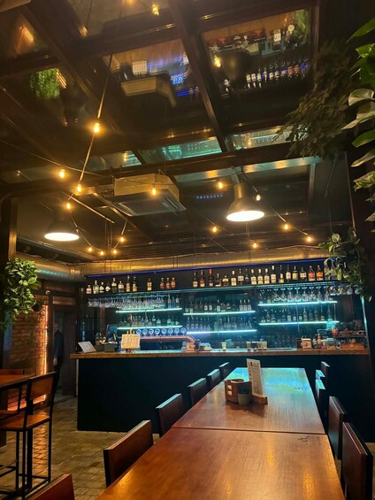 A bar with wooden tables and a high ceiling with exposed beams. 4