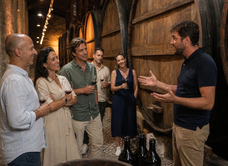 A group of people in a rustic cellar with wooden barrels and bottles. 5
