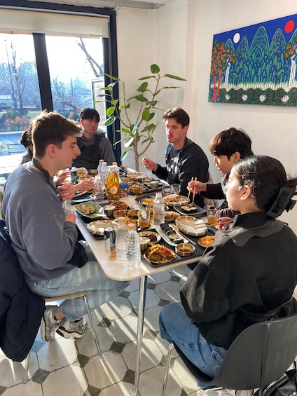 A group of people dining at a table with various dishes and drinks. 1