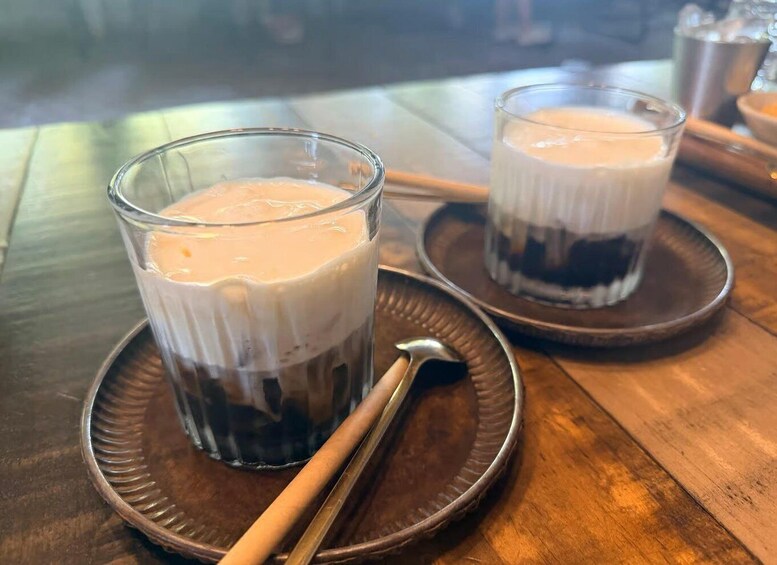 Two glasses of iced coffee on a wooden table with a spoon. 2