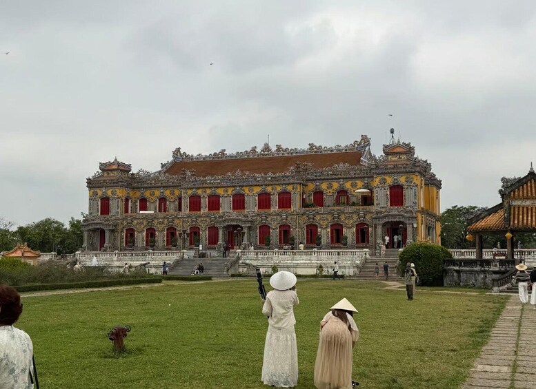 A large ornate building with red doors and a garden in front. 4