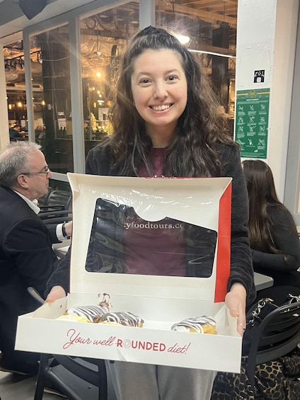 A person holding a box of donuts with a sign that reads 'Your well ROUNDED diet!' 2