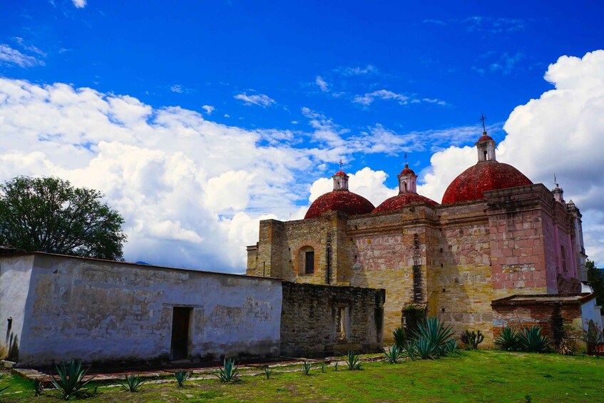 A historic church with red domes and a white building in the foreground. 4