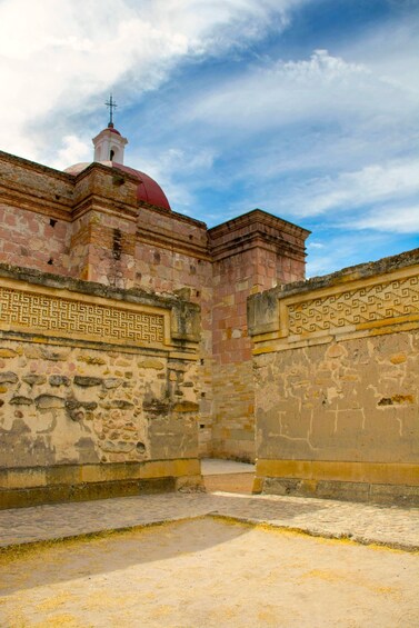 An ancient stone building with a red dome and intricate carvings. 5
