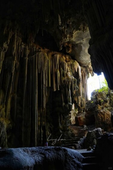 A cave with stalactites hanging from the ceiling and a rock formation at the bottom. 3