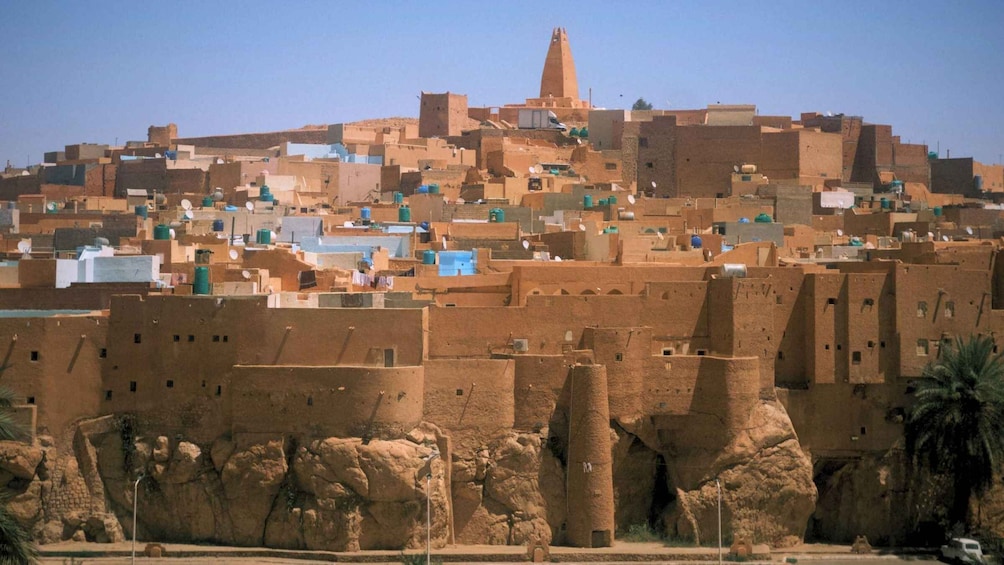 A desert town with adobe buildings, a prominent minaret, and rocky terrain. 5