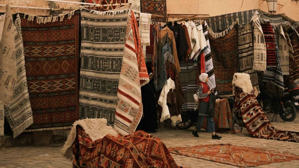A market stall with various textiles and rugs. 3