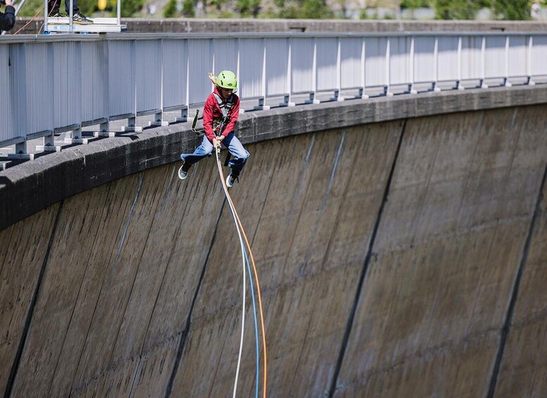 A person rappelling down a concrete dam. 4