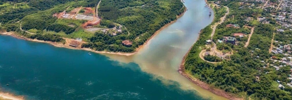 A river winding through a densely forested area with a small settlement along its banks. 5