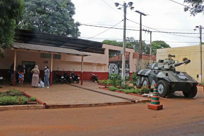 A military vehicle parked in front of a building with a sign reading 'DECEPCION.' 1