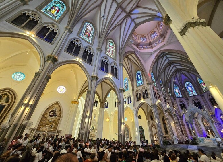 A cathedral interior with high vaulted ceilings, stained glass windows, and a congregation. 3