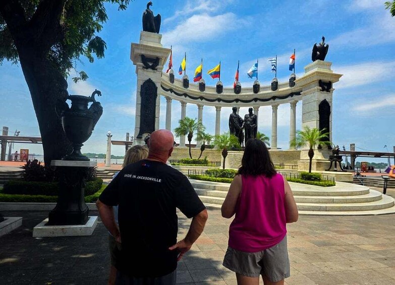 A monument with flags, statues, and a fountain. 5