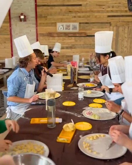 A group of people dining at a wooden table with yellow plates and white napkins. 5