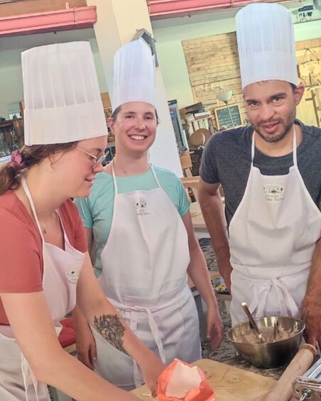 Three people in aprons and chef hats, engaged in a cooking activity. 2