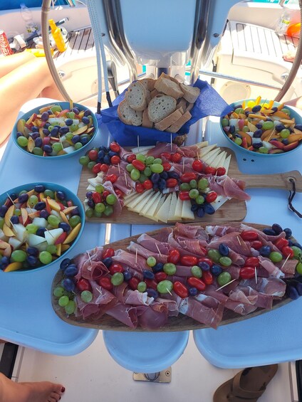 A table with various food platters including grapes, cheese, and cured meats. 3