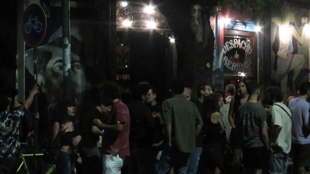 A crowded street scene at night with illuminated signs and a bicycle lane sign. 4