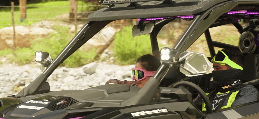 A Polaris RZR with a driver and passenger, both wearing safety gear. 4