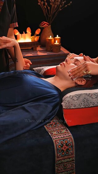 A person receiving a massage with candles in the background. 1